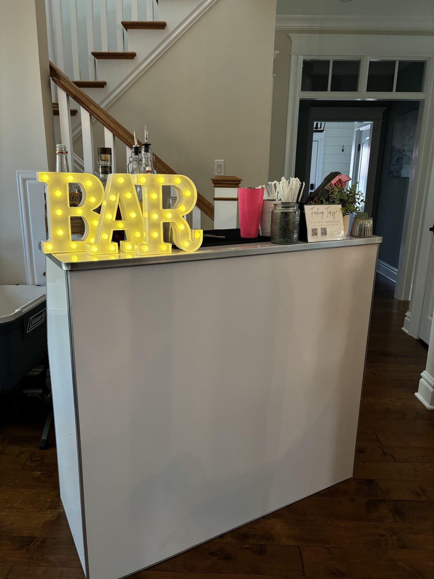 The Pop Up Bar with lit BAR letters set up in the front hall of a home for a private party.